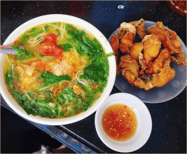 Bát bún cá vàng giòn, nước dùng trong veo, điểm xuyết rau xanh tươi