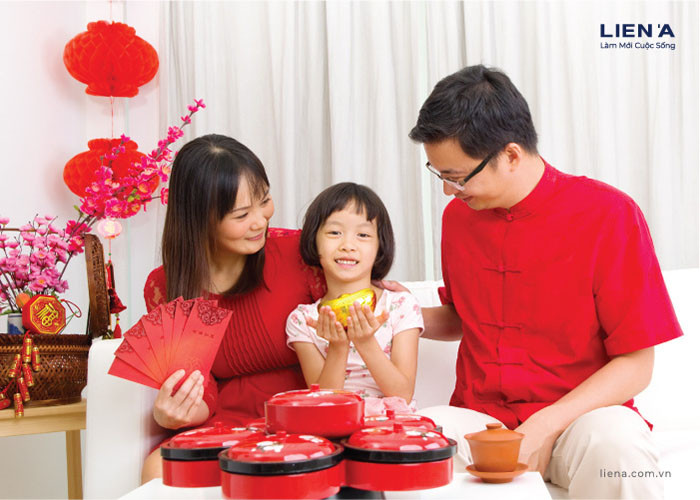 Bé gái đáng yêu mặc áo dài đỏ đang đọc bài thơ chúc Tết cho cha mẹ.