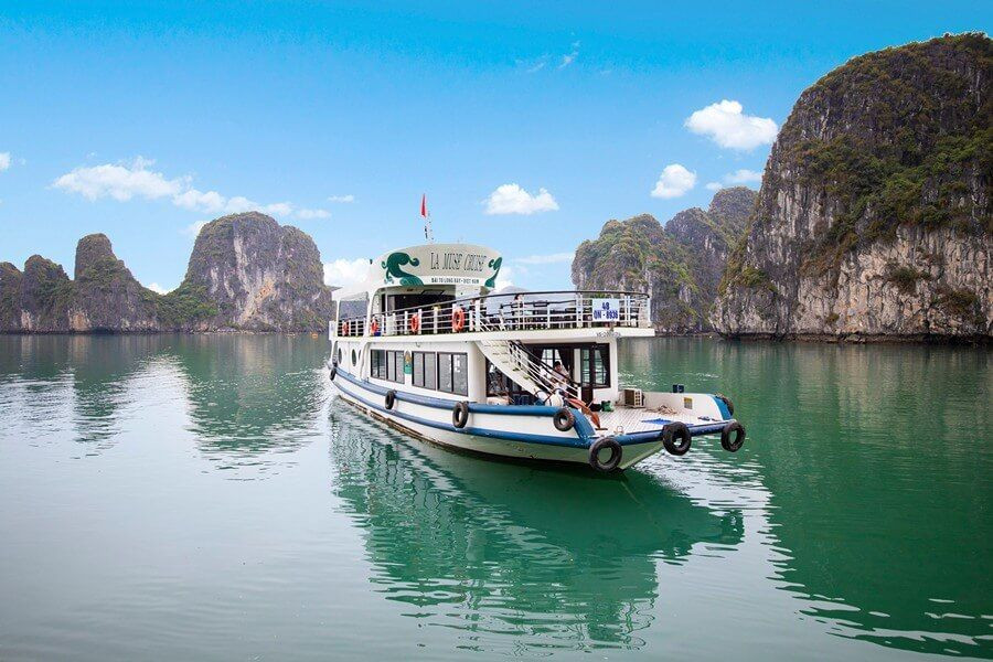 Một chiếc tàu du lịch hiện đại đang lướt nhẹ trên làn nước xanh biếc của vịnh Hạ Long.