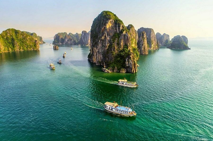Một chiếc tàu du lịch trên vịnh Hạ Long với hành khách đang ngắm cảnh, dành cho tour 6 tiếng.