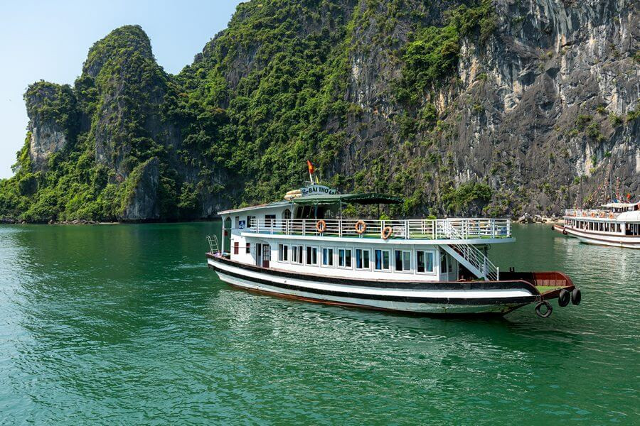 Một chiếc tàu du lịch truyền thống đang di chuyển trên vịnh Hạ Long trong chuyến tham quan 4 tiếng.